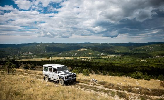 4x4 off-road vehicle driving through the Istrian countryside with vineyard views during a Hedonistria tour