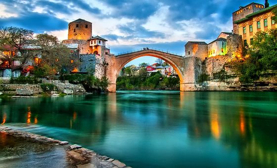 Stari Most bridge in Mostar illuminated at dusk over the Neretva River