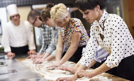 Participants making fresh homemade pasta from scratch during a cooking workshop in Istria