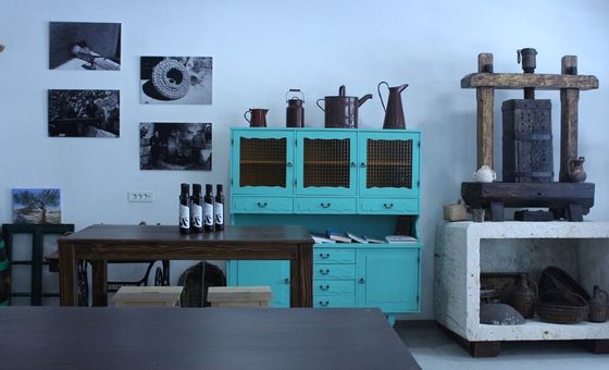Traditional olive oil museum interior with antique oil press and vintage tools on display