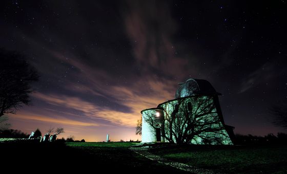 Astronomical observatory in Višnjan illuminated at night beneath a star-filled sky